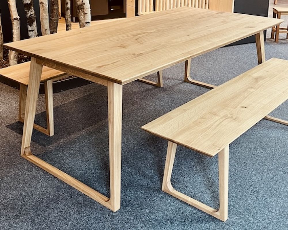 Moderner Esstisch aus Massivholz Eiche mit passender Sitzbank und natürlicher Holzmaserung vom Tischler.